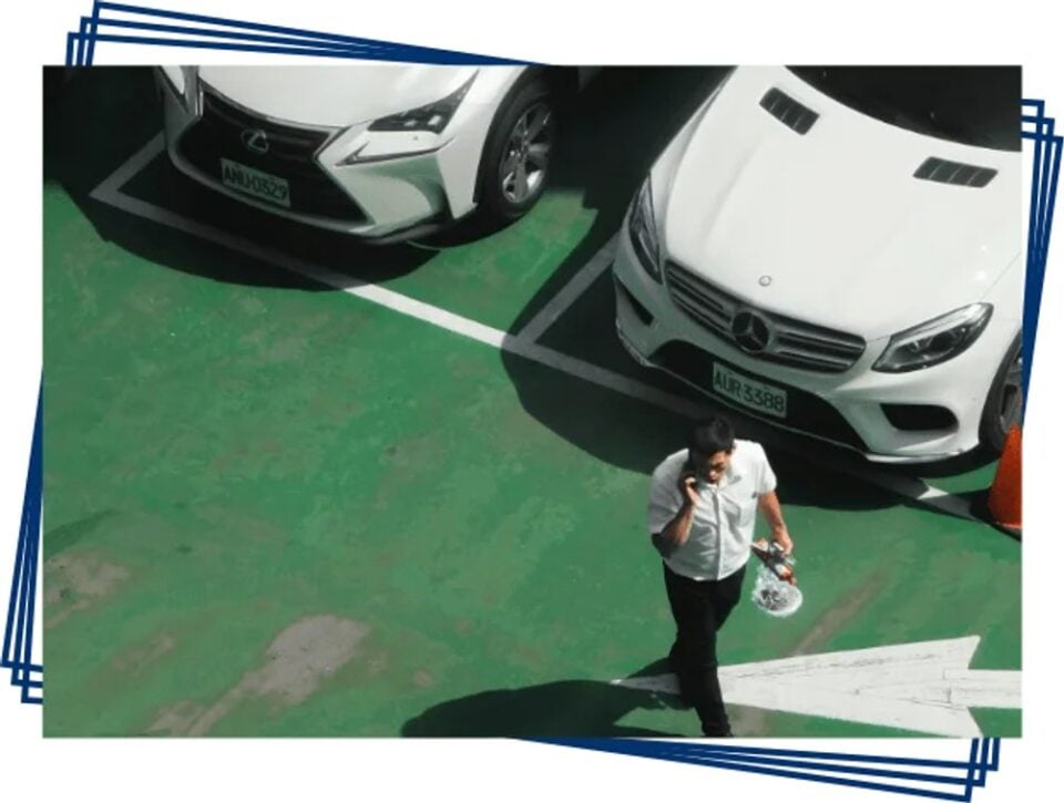 Traveller walking between parked cars at an airport car park