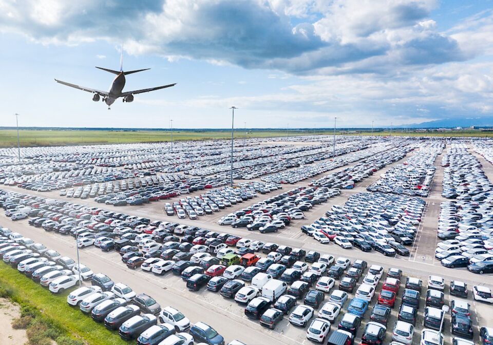Airport parking scene showing rows of parked cars