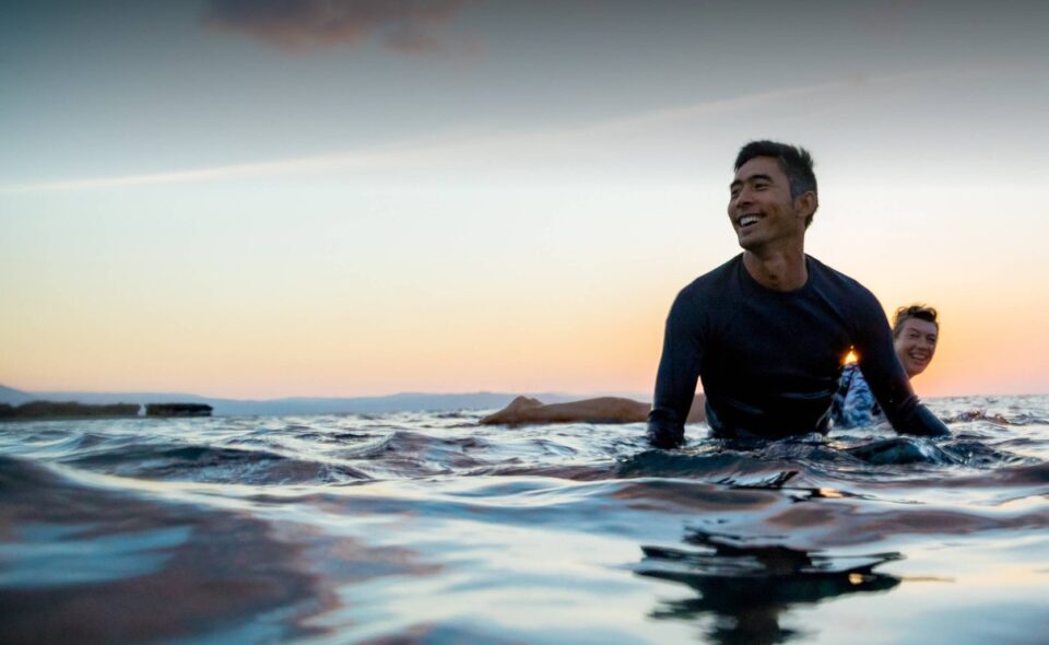 Surfer auf dem Wasser als Reiseszene für die Platinum Card