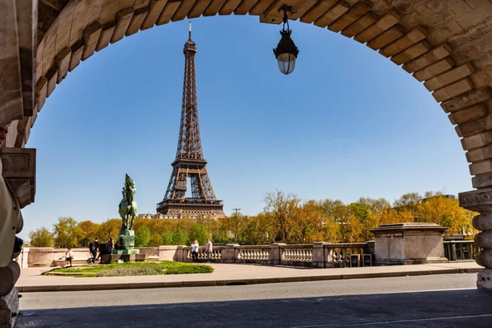 Torre Eiffel vista sotto un arco in pietra