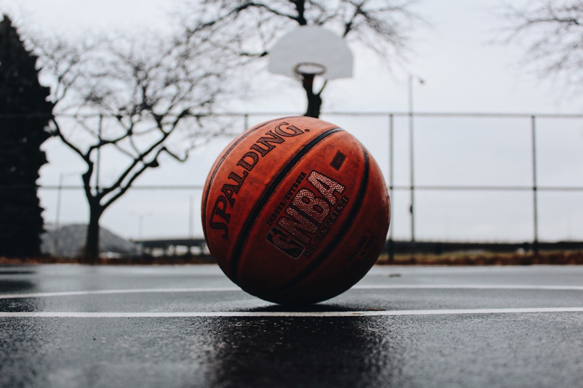 Outdoor basketball hoop against a bright sky