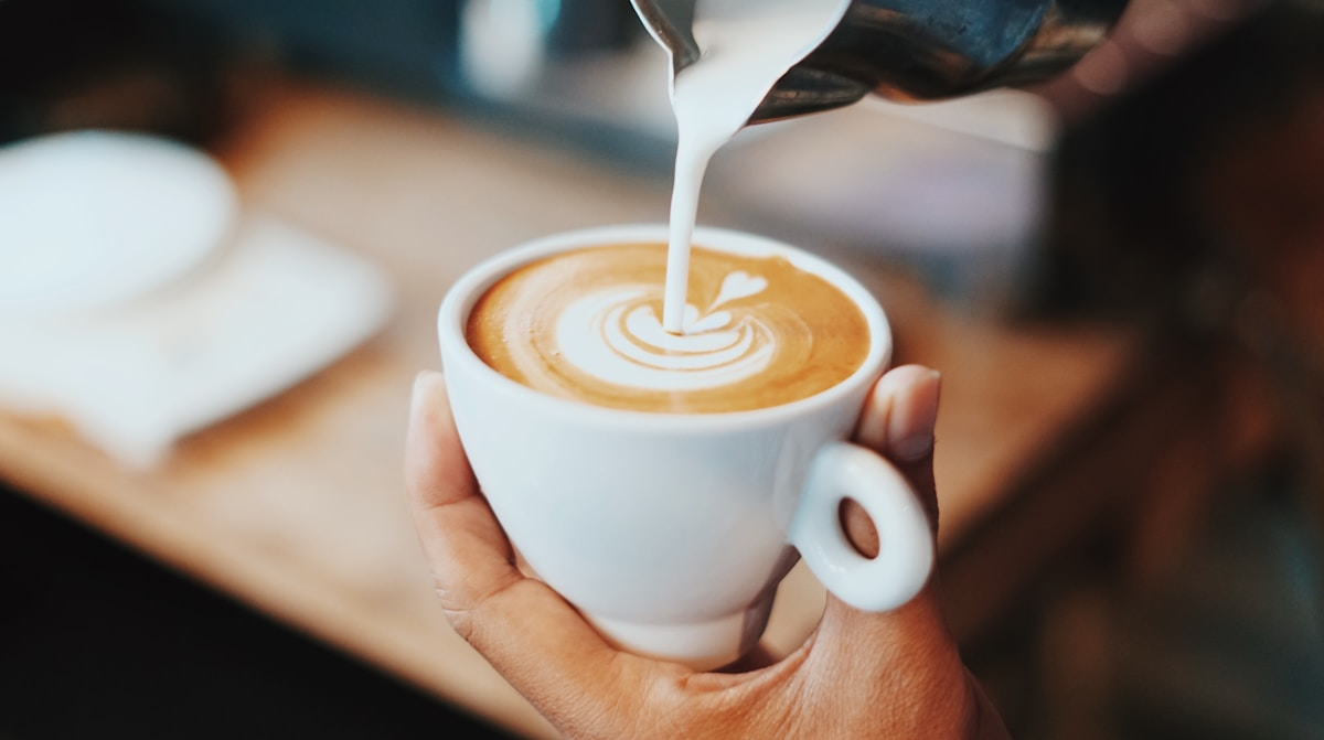 Latte art being poured into a cup