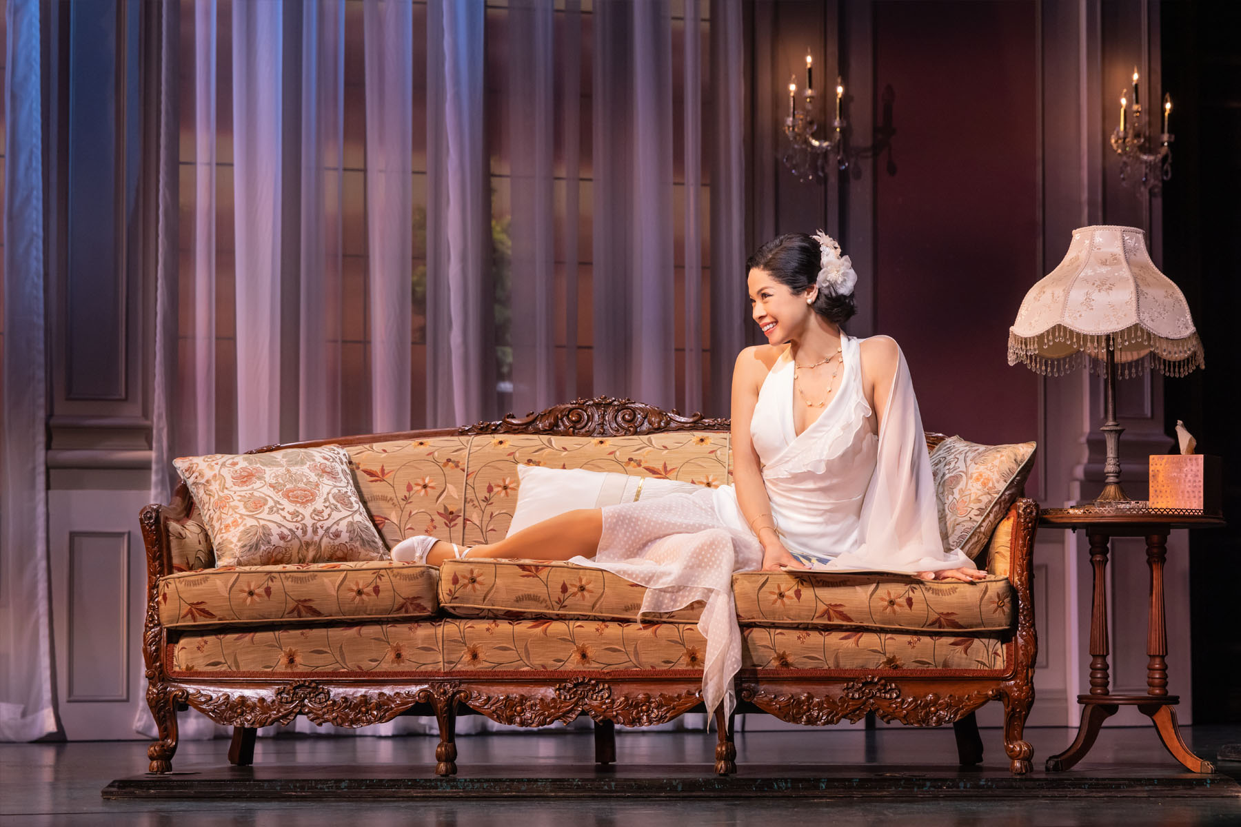 Woman reclining on a couch in The Great Gatsby musical