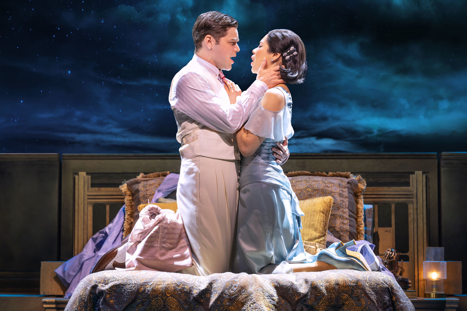 Couple singing together on a bed in The Great Gatsby musical