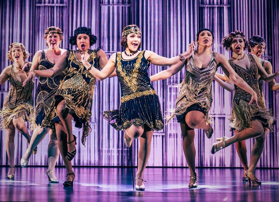 Flapper ensemble dancing at an extravagant Great Gatsby Broadway party scene