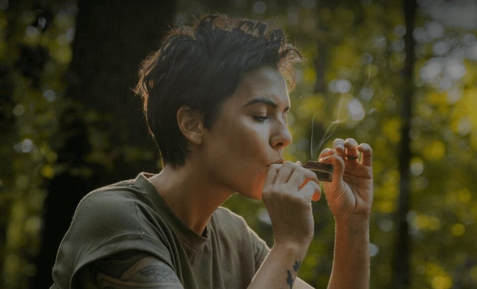 Person smoking cannabis outdoors in a forest