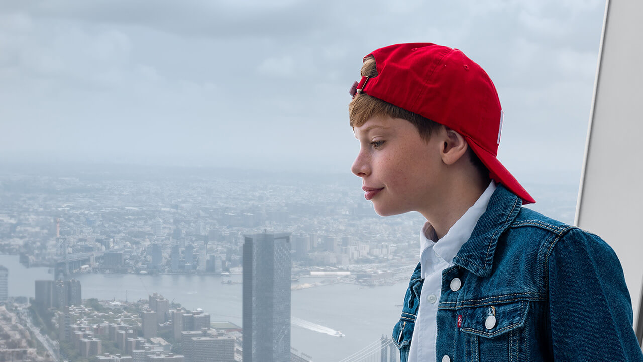 Garçon regardant la skyline de New York depuis l'observatoire