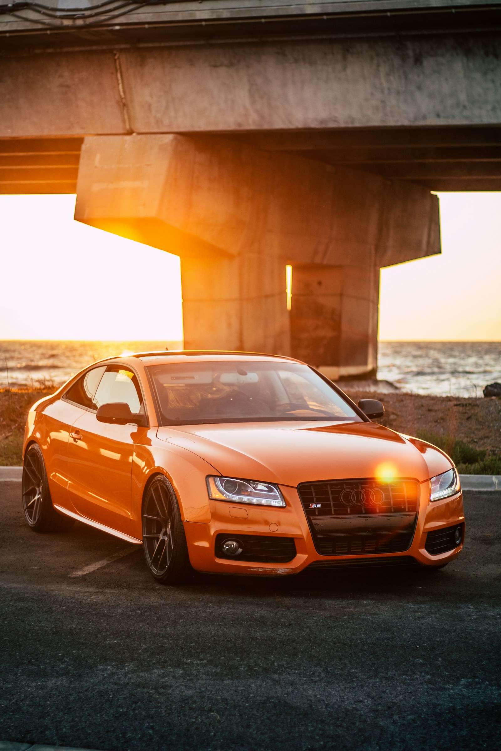 Oranges Coupé unter einer Brücke
