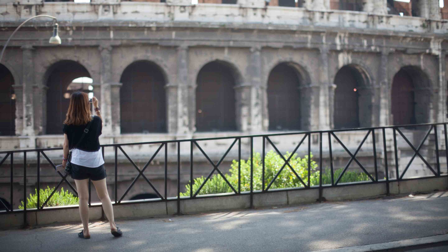 Woman photographing the Colosseum in Rome