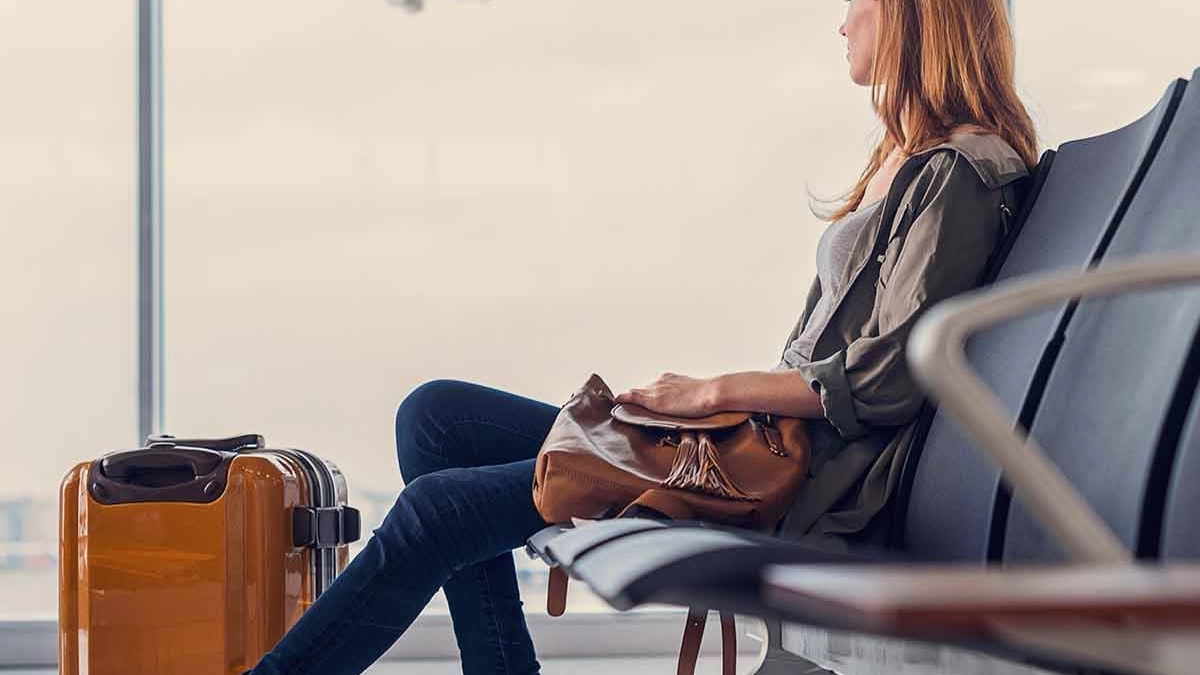 Woman sitting in an airport with luggage