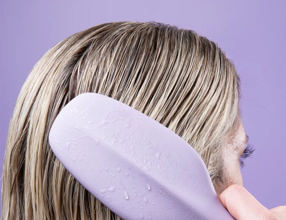 Model using the Cliphair detangling hairbrush on long hair