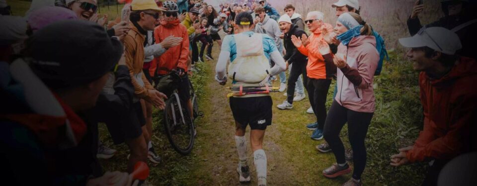 Runner moving through a cheering crowd for Compressport