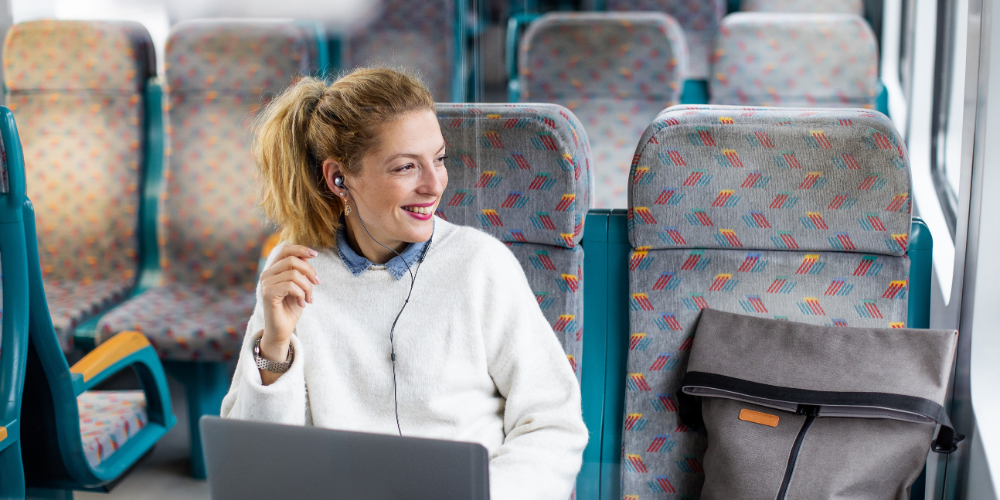 Frau arbeitet während einer Zugfahrt am Laptop