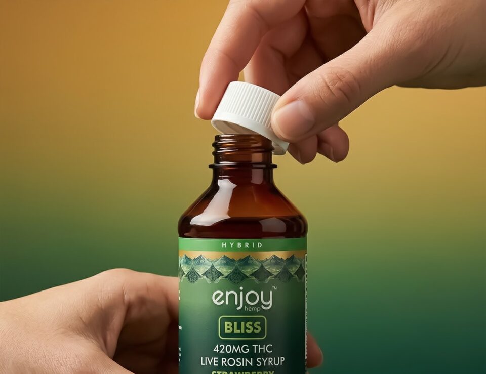 A hand opening an Enjoy Hemp Bliss live rosin syrup bottle