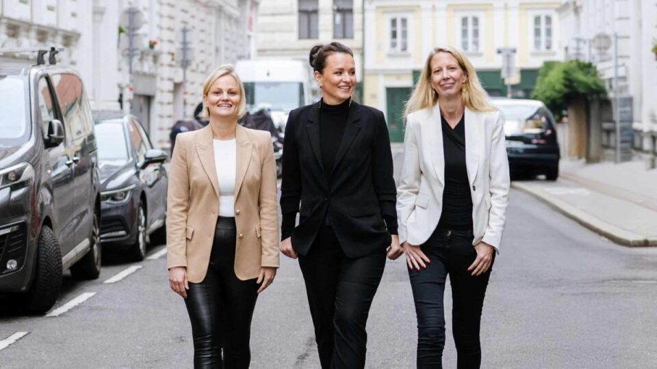 Drei Frauen gehen gemeinsam durch eine Straße
