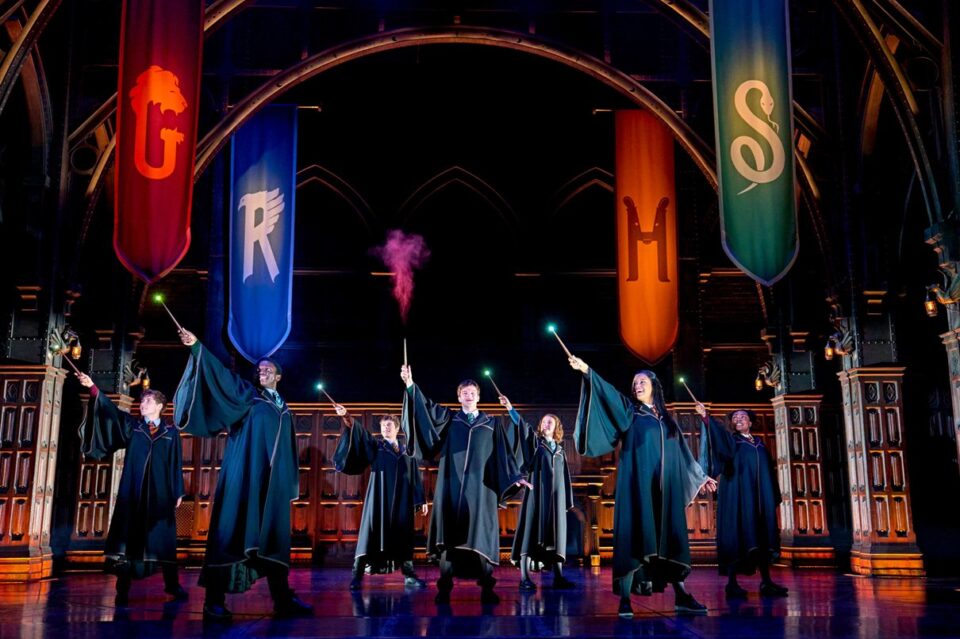 Students waving wands during a Harry Potter and the Cursed Child stage performance