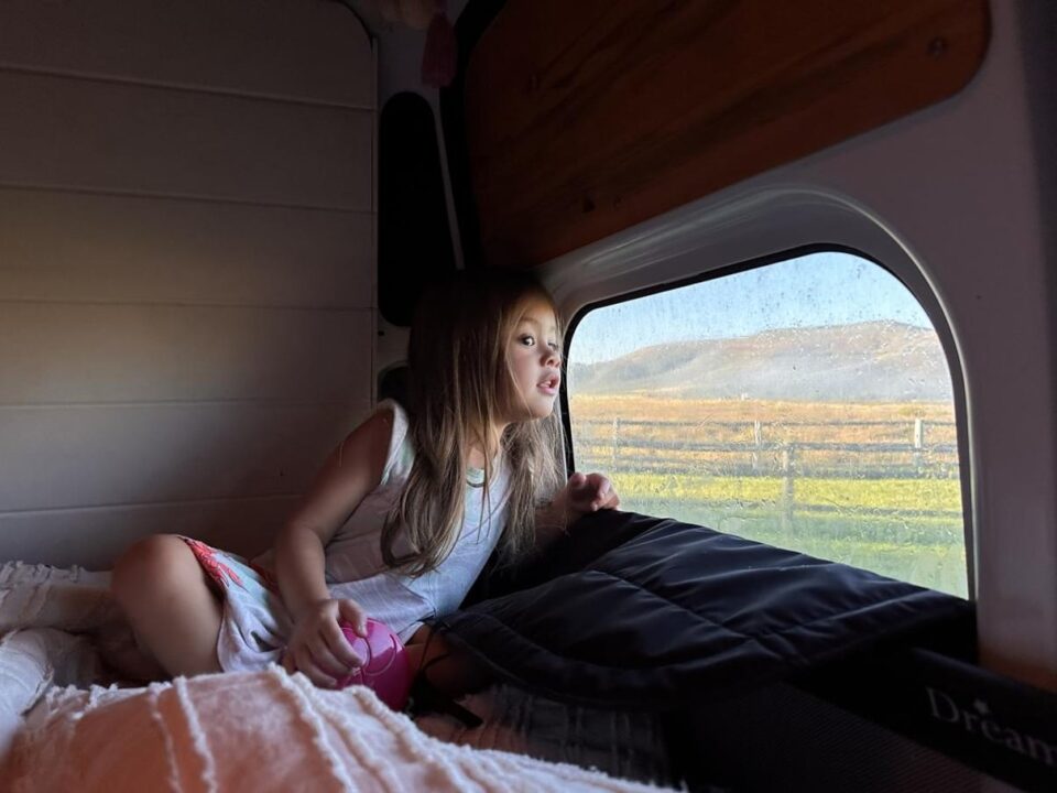 Child relaxing inside a camper van during an RV trip