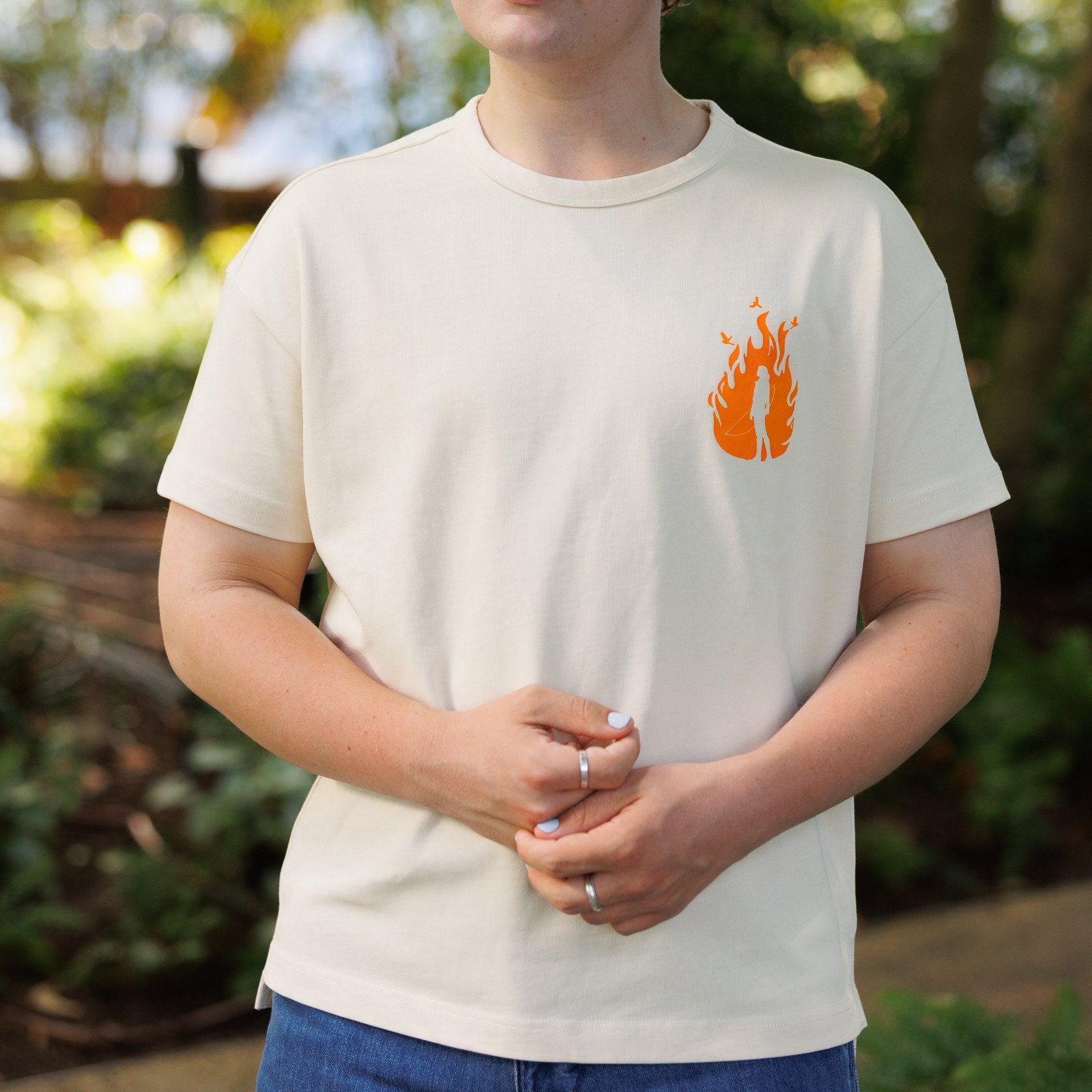 Cream Hunger Games on Stage T-shirt with a flame graphic