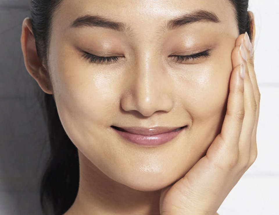 Woman touching her face during a Kiehl's skincare routine