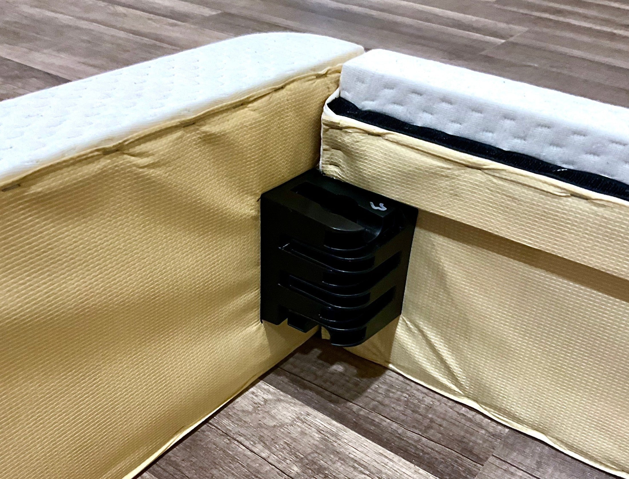 A close-up of a mattress foundation corner connector from Latex Mattress Factory