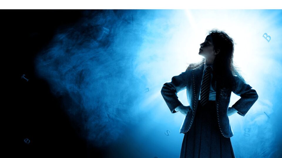 Silhouetted girl standing on the Matilda The Musical stage