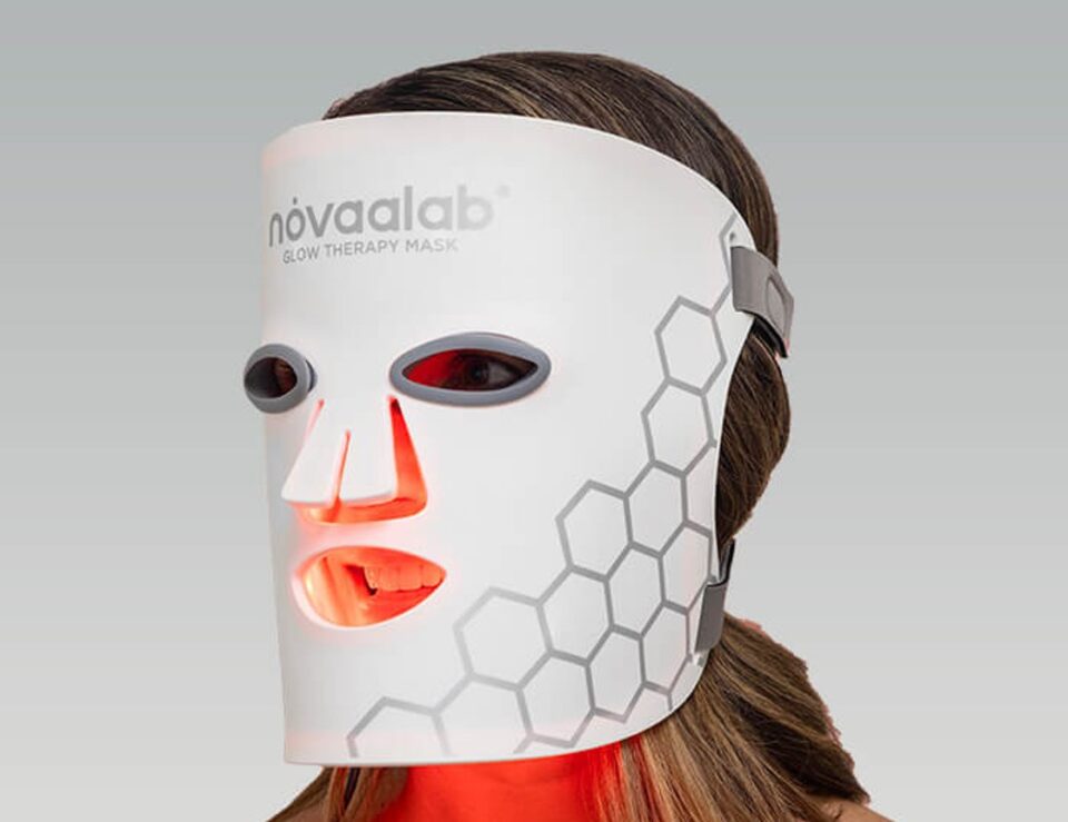 Woman using an LED glow therapy mask at home