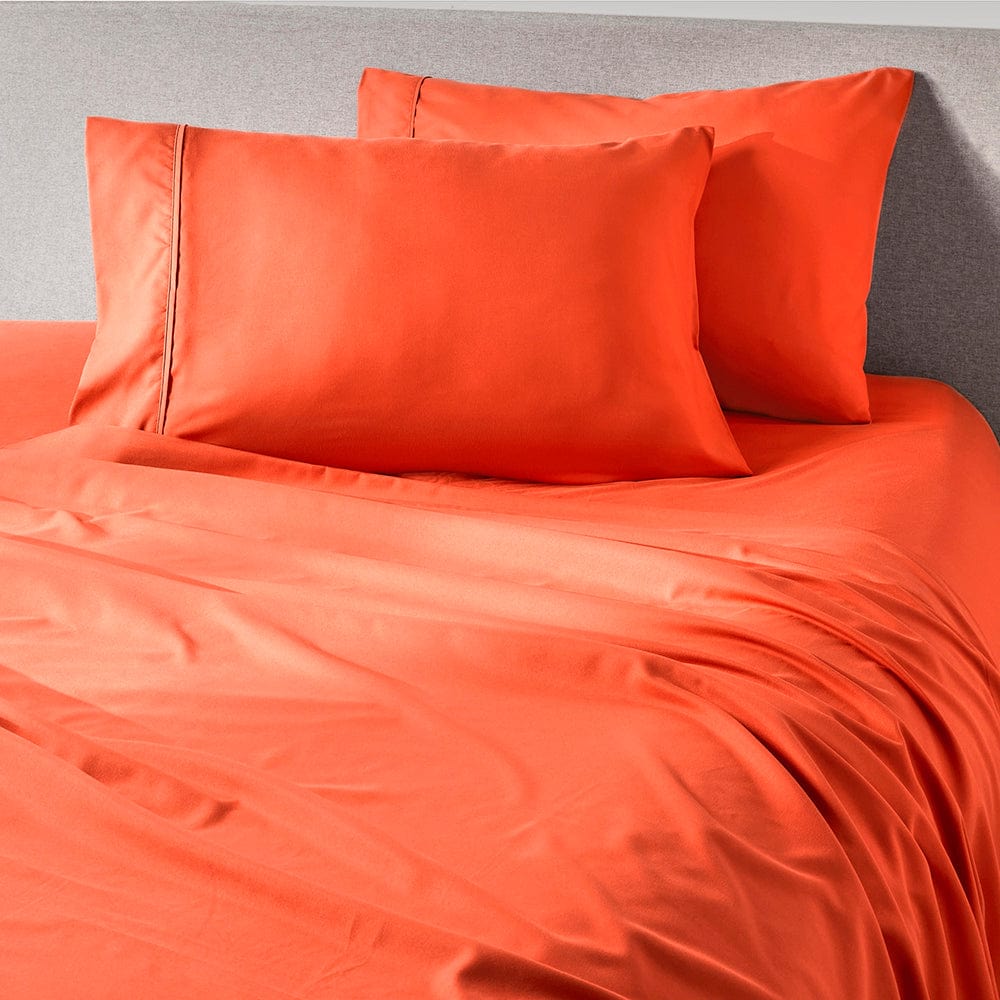 Hot Coral sheets styled in a bedroom
