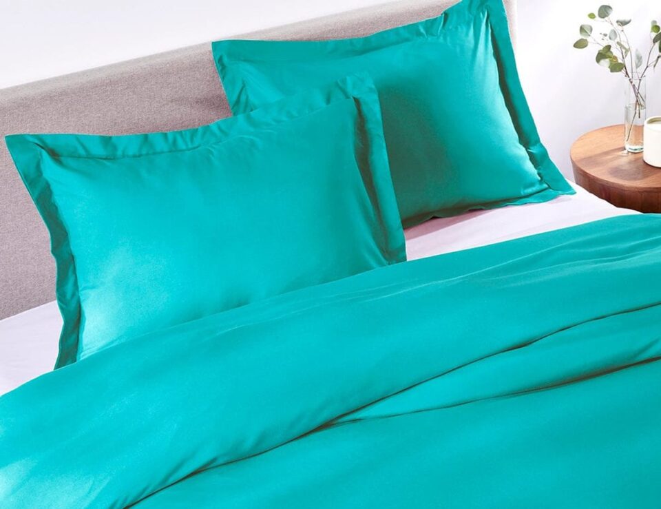 Tiki Turquoise duvet cover styled on a bed