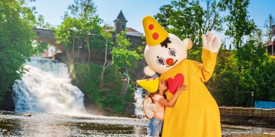 Famille rencontrant un personnage dans un parc Plopsa