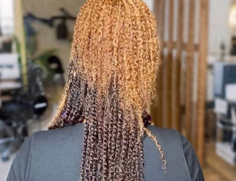 Person wearing a long curly human hair style in a home setting