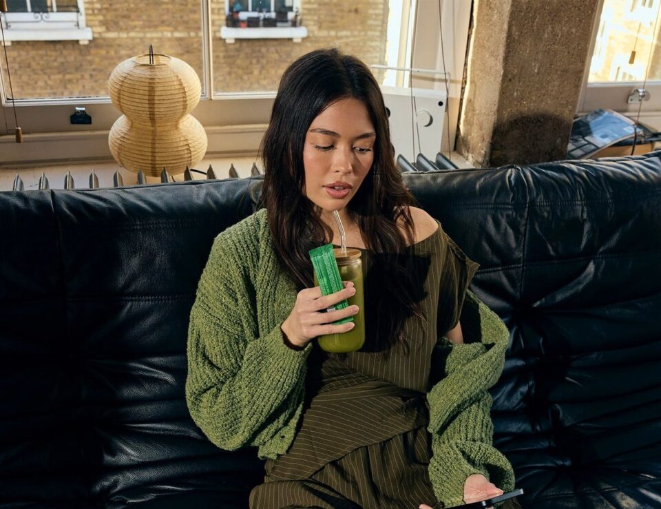 Woman drinking a green beverage during a daily drink ritual