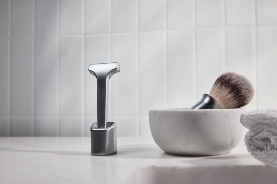 Supply razor, shaving brush, bowl and towel arranged for a grooming ritual