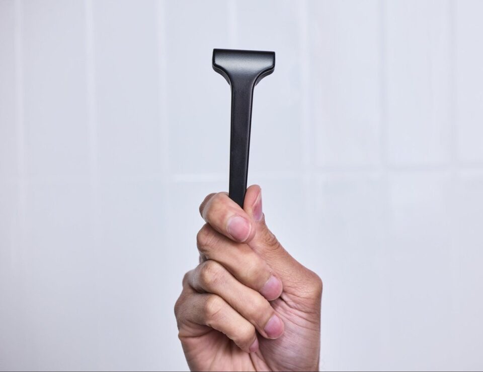 Hand holding a black Supply razor