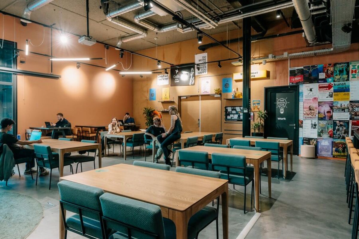 Offener Coworking-Bereich des The Social Hub Amsterdam mit Gemeinschaftstischen