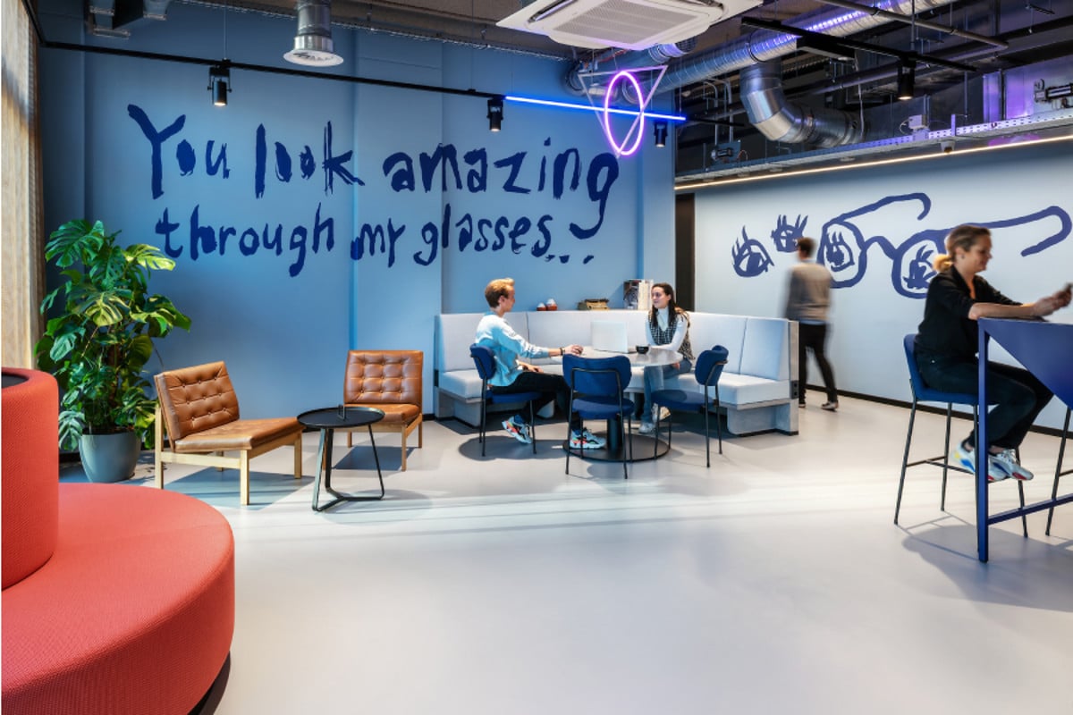Gemeenschappelijke ruimte met blauwe wanden in The Social Hub Delft