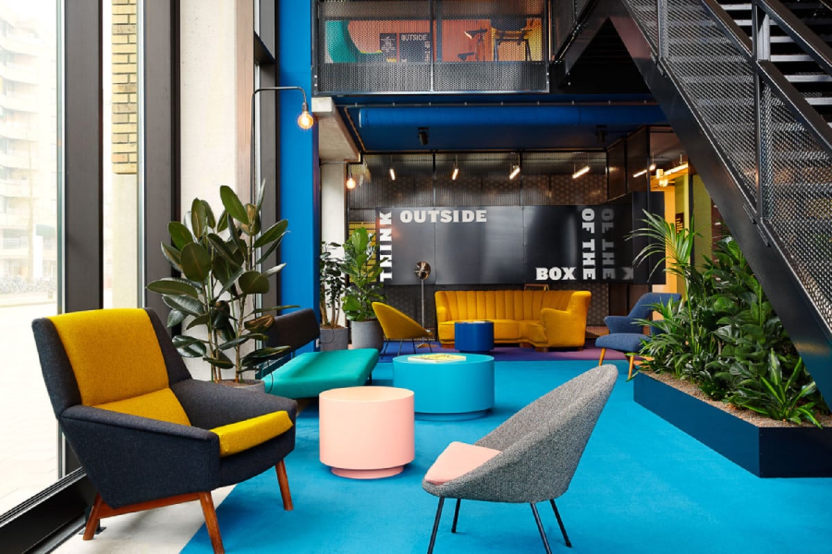 Gemeenschappelijke ruimte met zitplaatsen en trap in The Social Hub Eindhoven
