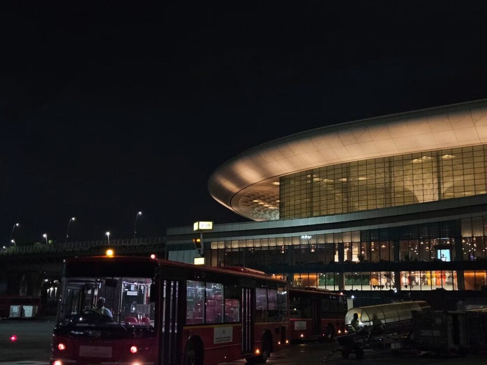 Airport terminal at night with a shuttle bus