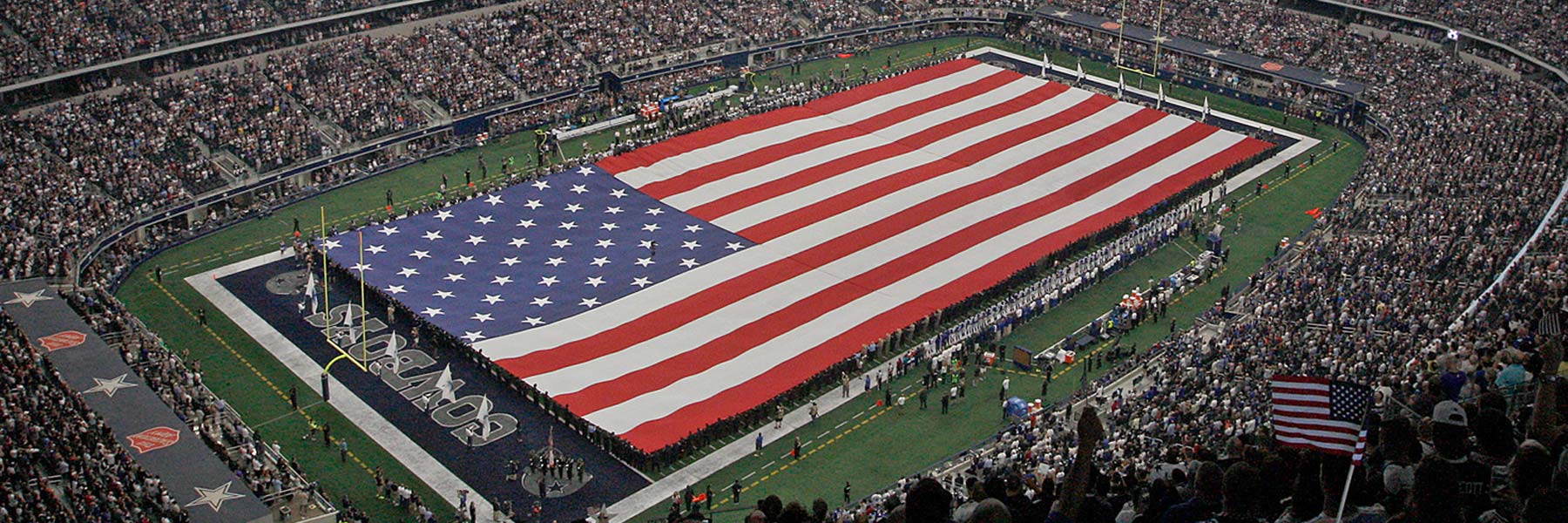 Dallas Cowboys field with a large flag at AT&T Stadium