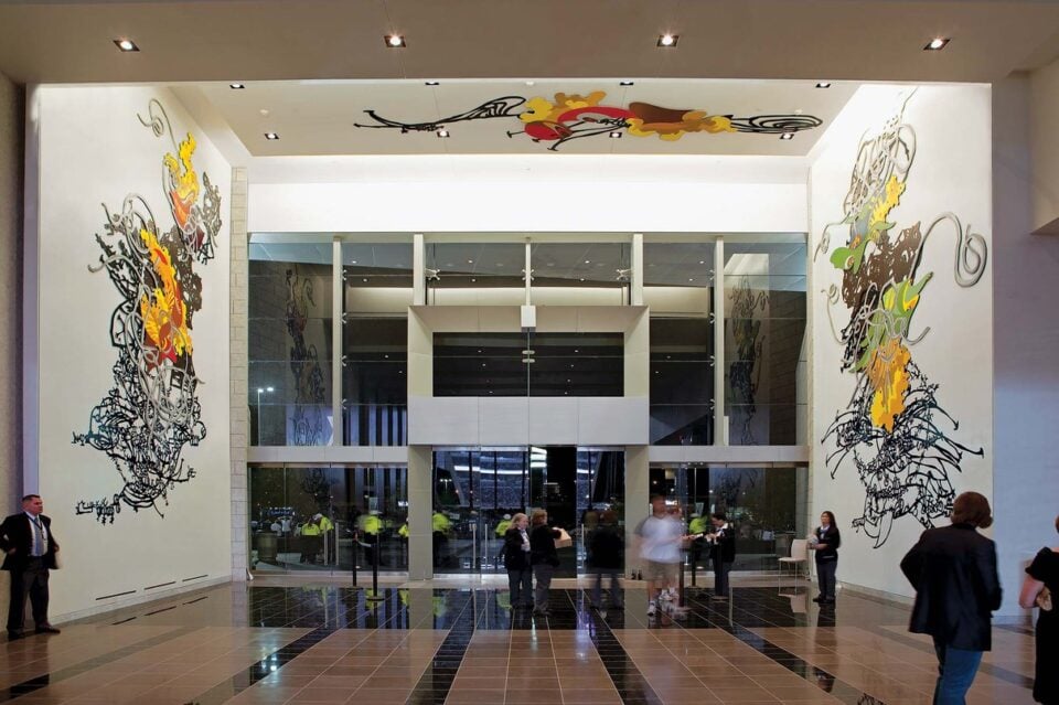 Visitors looking at a large artwork inside AT&T Stadium