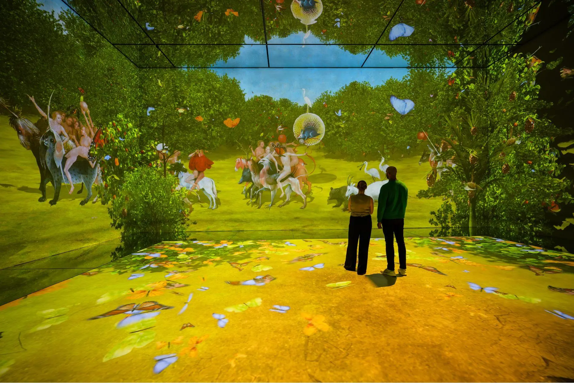 Visitors looking at projected artworks in a Frameless gallery