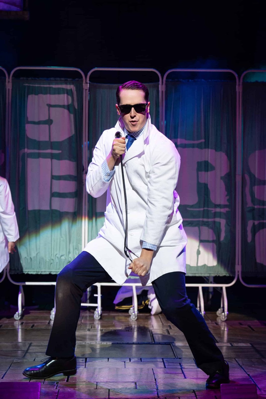Performer in a white suit on the Matilda stage