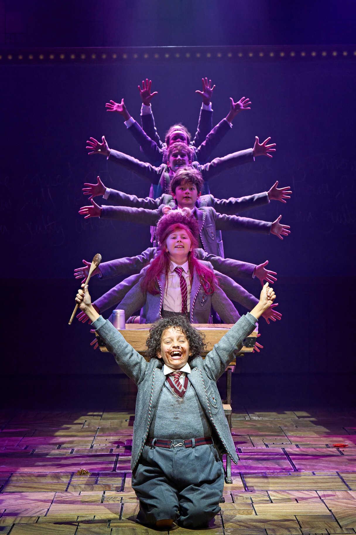 A theatrical scene from Matilda The Musical with performers on stage