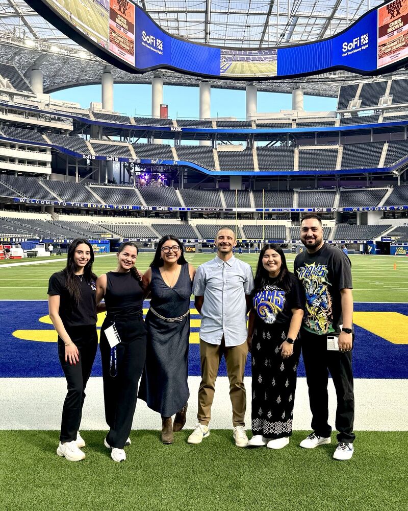 A small group on the SoFi Stadium field during a tour