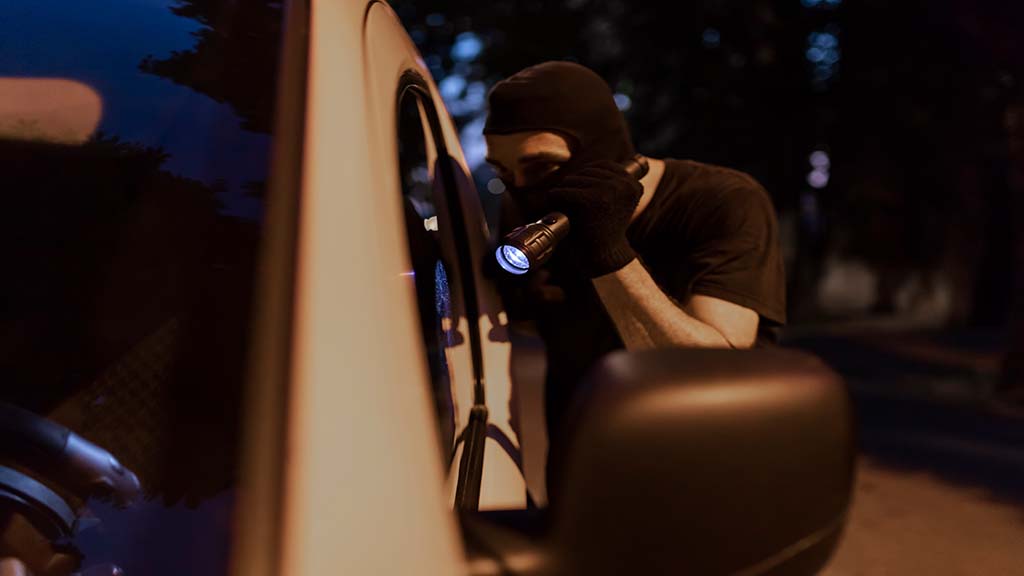Vermummte Person kontrolliert ein Auto